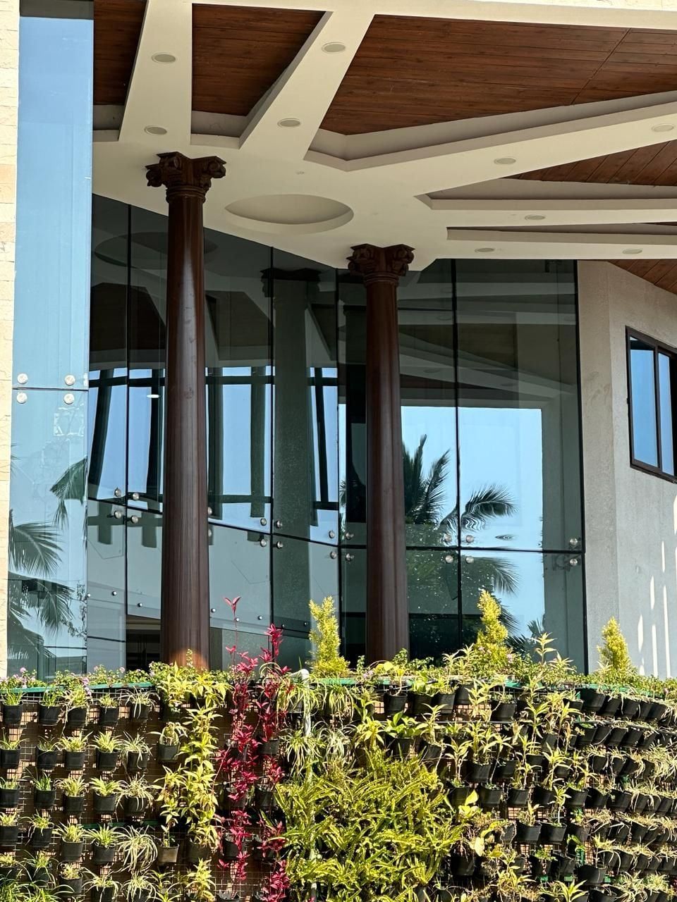 Columns and capitals at the glazed entrance — Aayakar Bhavan, Kochi, Kerala