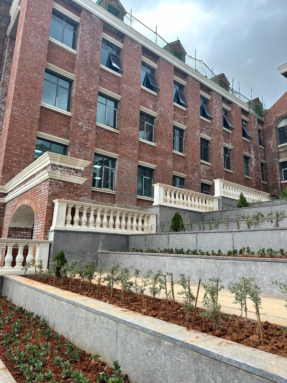 Balustrades along the terraces, and the arched entrance porch — Harrow International School