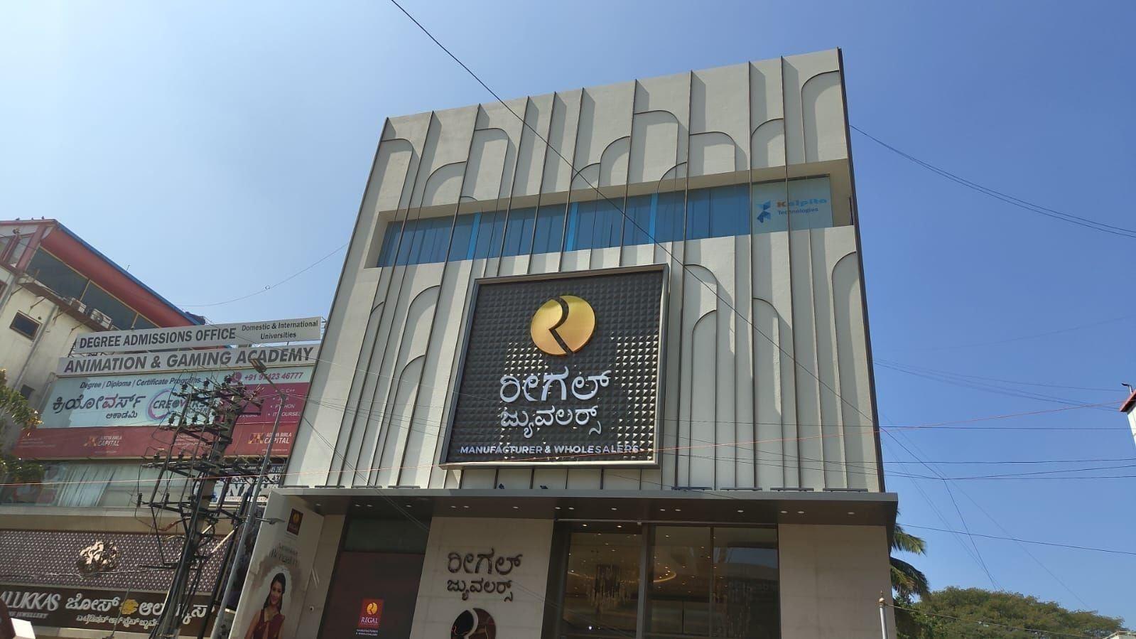 The showroom from the street: ribbed panels and the central sign panel — Regal Jewellers, Bangalore, Karnataka