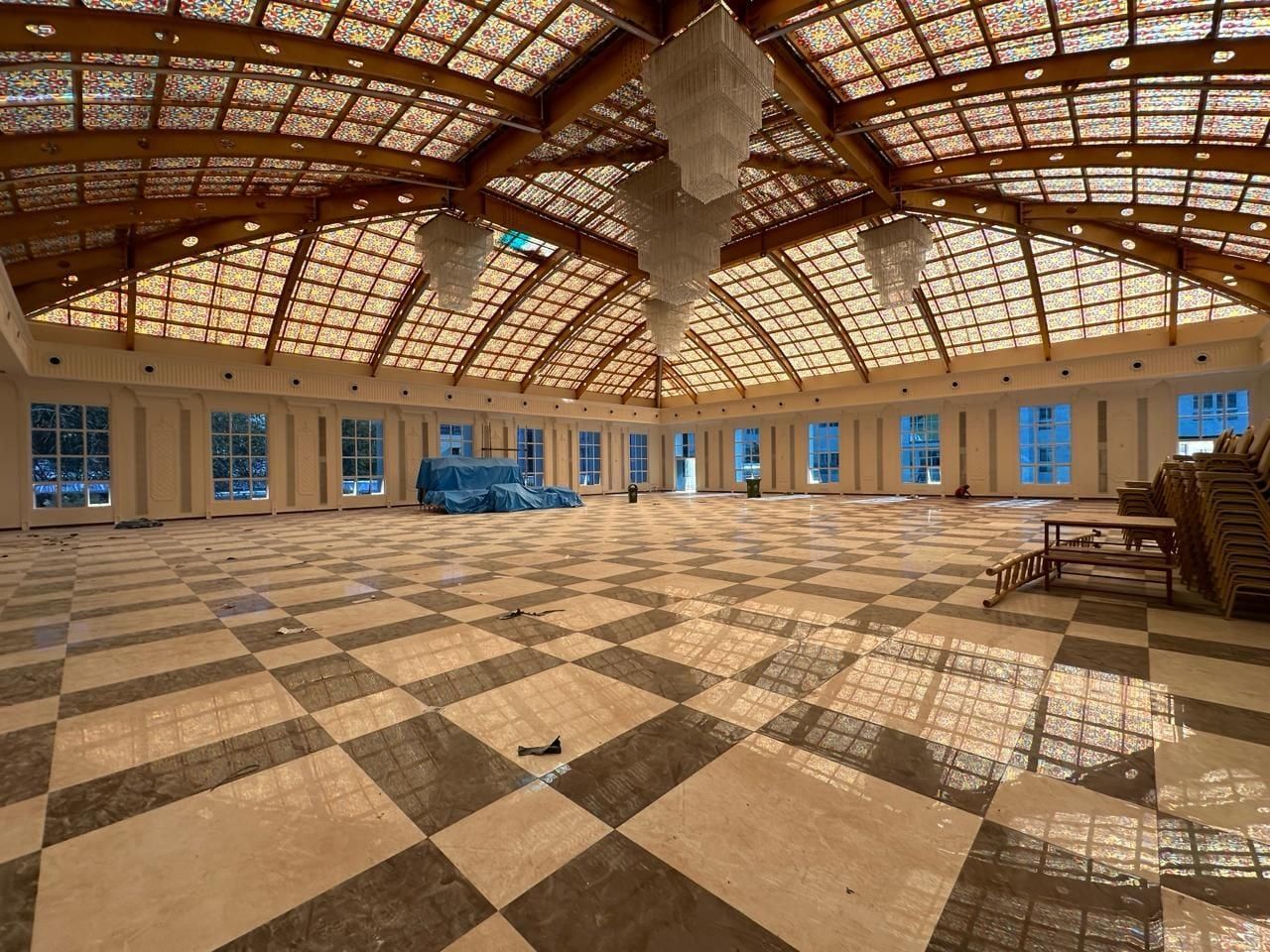 The hall inside, lined with arched windows under the skylit roof — Venkatamma Ramaiah Kalyana Soudha